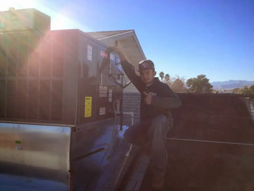 HVAC technician performing HVAC Inspection on a rooftop unit in Palmview